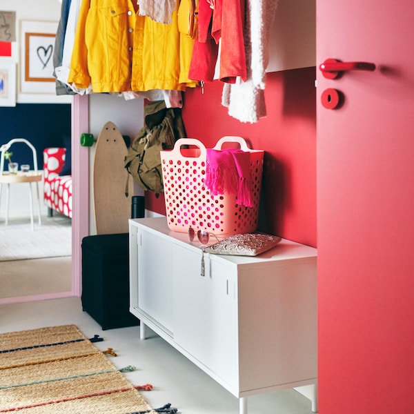 白色MACKAPAR反对有储物空间粉红色的墙壁上面挂着外套和一篮子。
