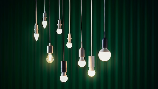 9各设计LED灯泡挂在不同的高度在一个黑暗的背景下绿色的窗帘。