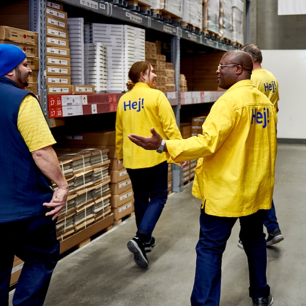 四个宜家同亚博平台信誉怎么样事,三个穿着黄色的t恤和一个身穿蓝色背心,自助服务区域的宜家商店。