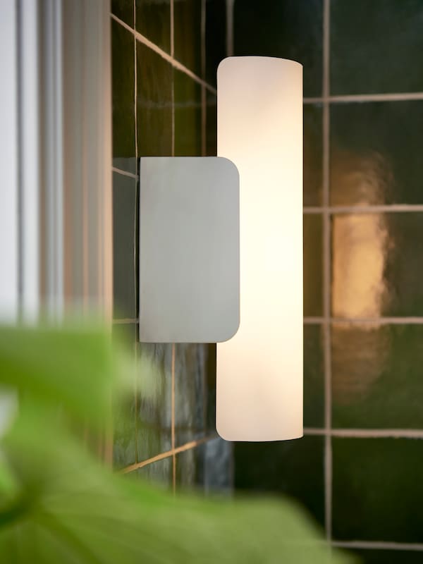 一架白色HAVSDUN可控LED壁灯white-frosted玻璃遮阳窗户旁边的客房的浴室里铺着绿色的。