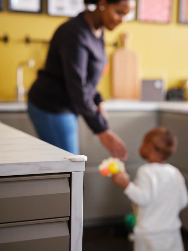 一个女人和一个孩子在一个厨房白色UNDVIKA角落保险杠的一角白色大理石桌面效果。