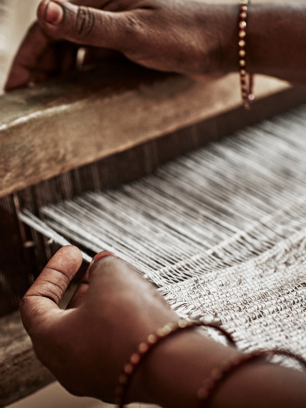 印度的手编织装饰着几个铜手镯,编织地毯织机。