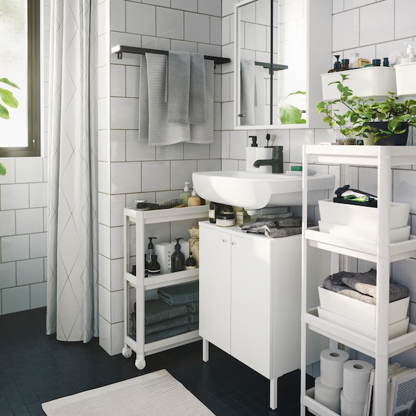 浴室VESKEN电车和搁置单元与毛巾,植物和美容产品,两侧的摆好。