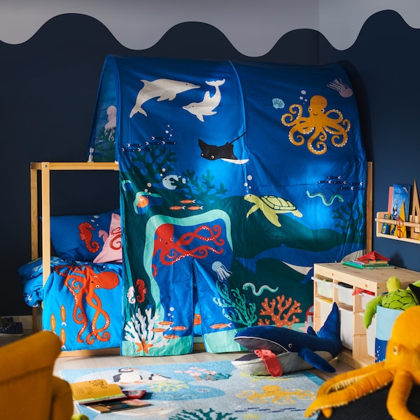 床上覆盖在库那的海洋动物床帐篷;BLAVINGAD蓝鲸软玩具BLAVINGAD地毯在它前面。