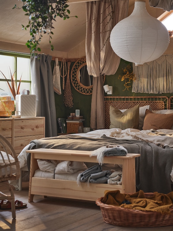 床与藤床头板在一个房间里挂中性颜色和白色织物RISBYN吊坠灯罩上面。