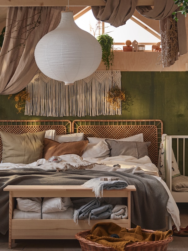 床与藤床头板在一个房间里挂中性颜色和白色织物RISBYN吊坠灯罩上面。