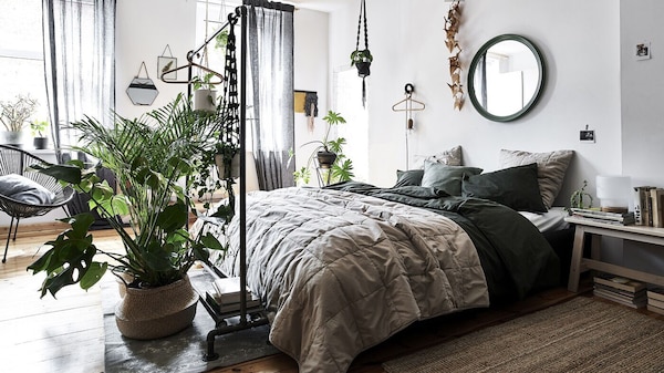 卧室与白墙、natural-coloured被褥和植物在柳条篮子。