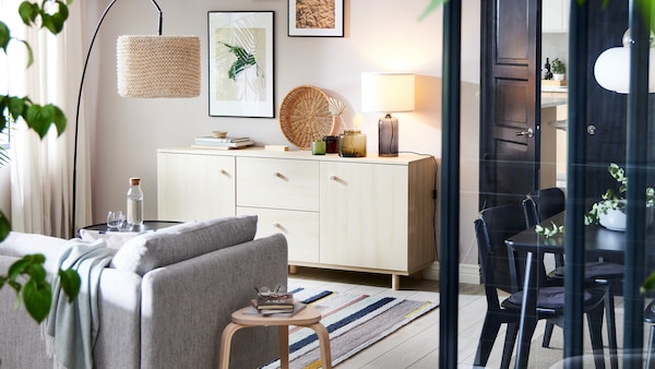 一个birch-effect ERSNAS桌子和白墙与米色/棕色SODERHAMN面前的沙发和一盏落地灯。