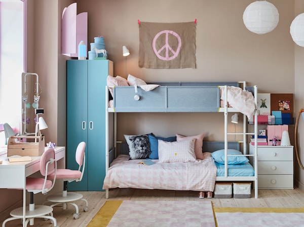 儿童蓝色和粉红色的房间对于白色双层床的兄弟姐妹,一个白色的共享办公桌和亮粉红色的桌子椅子。