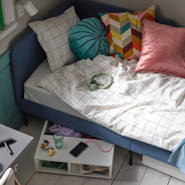 蓝色软垫床上白色/黑色检查VITKLOVER床单和各种垫子,与FREDVANG床下的存储。