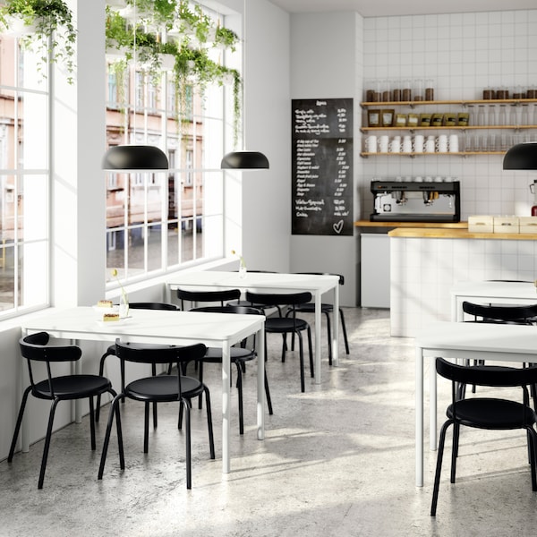 咖啡馆与白色TOMMARYD表、无烟煤YNGVAR椅子,一个计数器区域和一个大的黑白菜单。