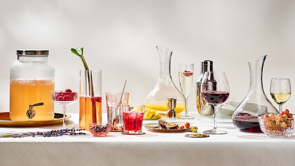 明确玻璃carfe和在各种不同的饮料酒杯和水杯放在桌子上白色的桌布。