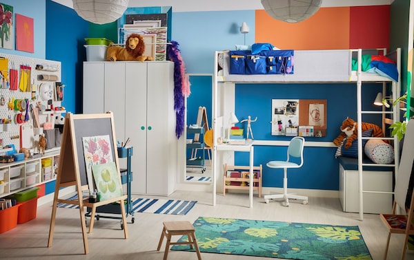 色彩缤纷的儿童房间,白色的阁楼床上,一个画架,leaf-patterned地毯和一个蓝色的儿童桌子椅子。