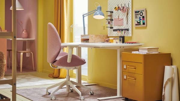 色彩缤纷的房间，工作区围绕白色TROTTEN办公桌和浅棕色和粉红色HATTEFJÄLL办公椅。