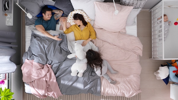 几个躺在大床上,他们的女儿是一个动物毛绒玩具玩。一个婴儿躺在SUNDVIK床附近。