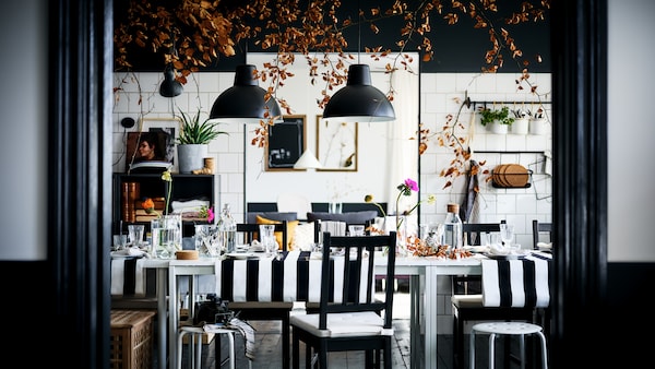 一个装饰华丽的黑白餐厅褐黑色STEFAN马吕斯椅子和凳子第二轮白MELLTORP表。