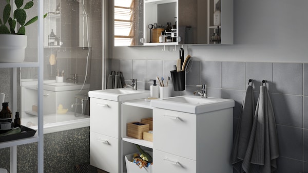 白灰色的浴室里,和盥洗池,内阁与镜子门和竹配件。