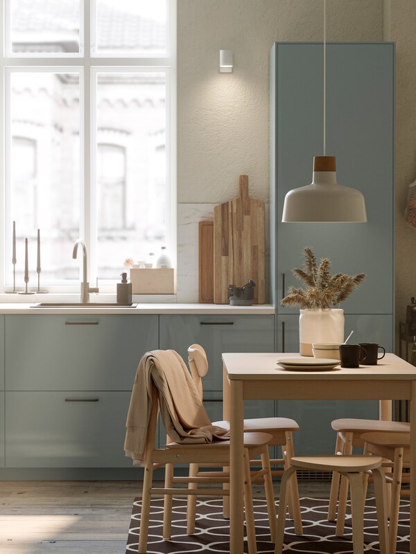 厨房与KALLARP厨房领域,RONNINGE桌子有四把椅子和一个BUNKEFLO吊灯在白色和桦树。