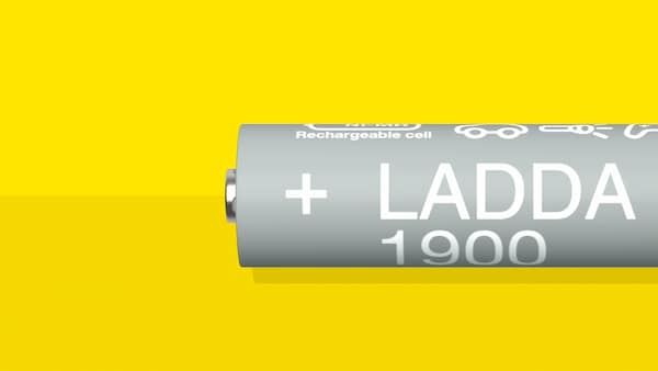 HR06 AA LADDA可充电电池,电池容量为1900 mah,躺在一个黄色的表面。