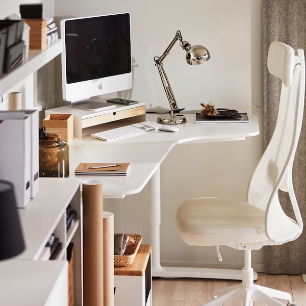 监视器监视站在白色BEKANT角落的桌子上有一个JARVFJALLET办公椅,加上一个白色缺乏墙书架上。