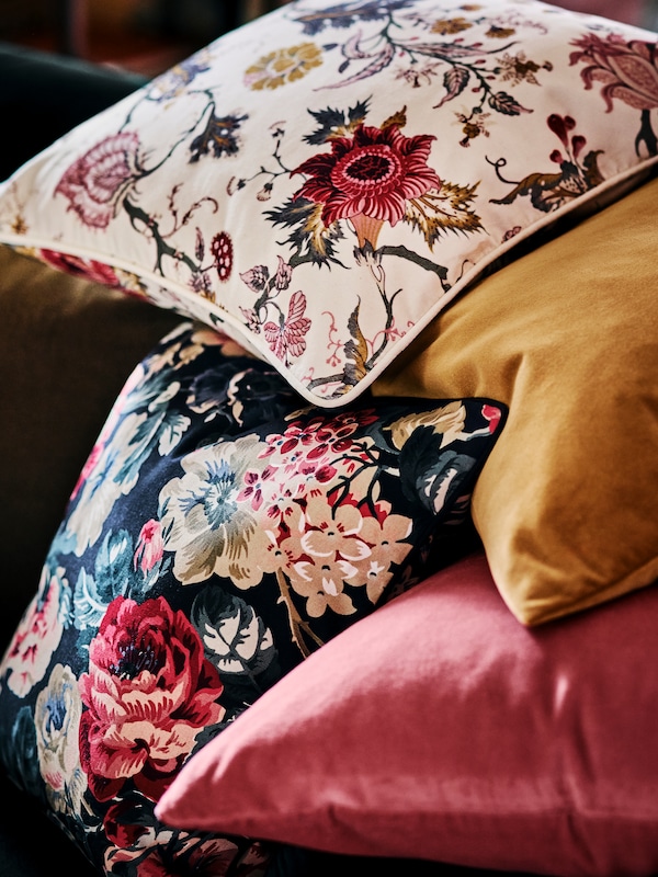 一堆垫由一个LEIKNY靠垫,一个NASSELKLOCKA花卉cusion盖,一个粉色,一个褐黄色。
