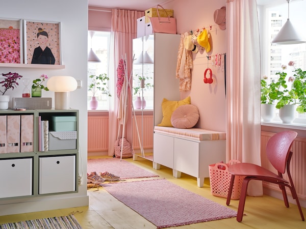粉红色的走廊PLATSA镜像的衣柜,板凳粉红色和黄色的靠垫,粉红色的地毯,挂帽子和围巾。