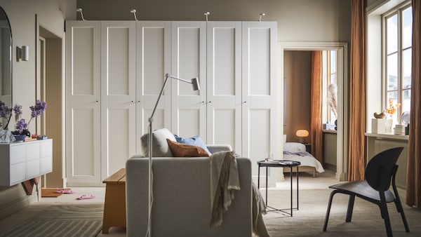 一个房间用米色VIMLE 2-seat床在中间和两个白色罗马/ GRIMO衣柜在后面的墙上。