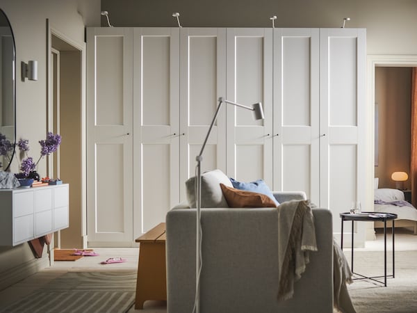 一个房间用米色VIMLE 2-seat床在中间和两个白色罗马/ GRIMO衣柜在后面的墙上。
