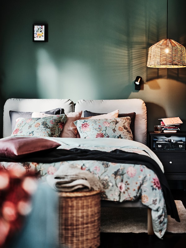 SAGESUND软垫床框、靠垫与粉红色和灰色SANELA缓冲封面和花朵图案NASSELKLOCKA床上用品。