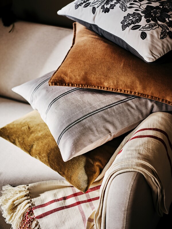 沙发,把和四个堆积成山的垫子,其中一人与一个灰色STORTIMJAN靠垫白色和暗条纹。