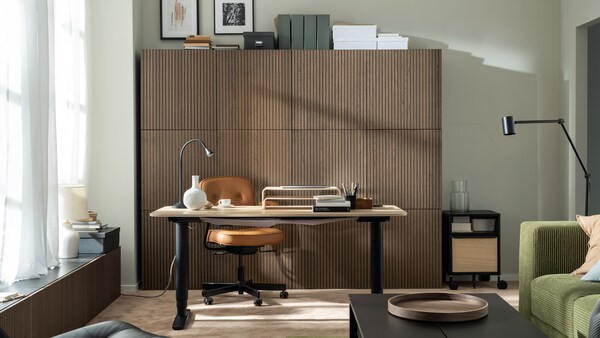 成立阳光工作区BEKANT坐立的桌子,一个ALEFJALL办公椅和一堵墙wood-front BESTA橱柜。