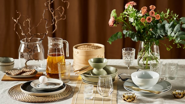 一个表显示三种不同的表设置,包括各种餐具、玻璃器皿、餐垫在花瓶和花。