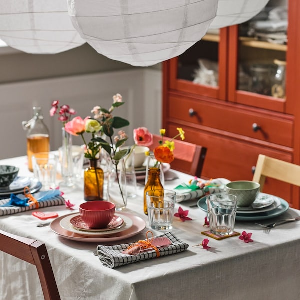 一套表与自然/米色桌布不同颜色混合餐具,突然眼镜和鲜花。