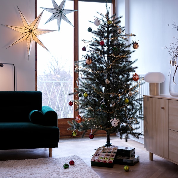 树是用装饰物装饰客厅设置;开放的装饰物和其他框是在树下。