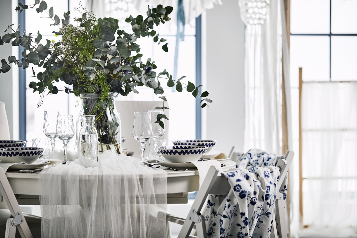 与花卉centerpeice婚礼表,蓝色织物支持联合国椅子和一套白色的传统餐饮。