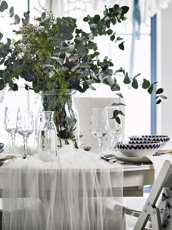 与花卉centerpeice婚礼表,蓝色织物支持联合国椅子和一套白色的传统餐饮。