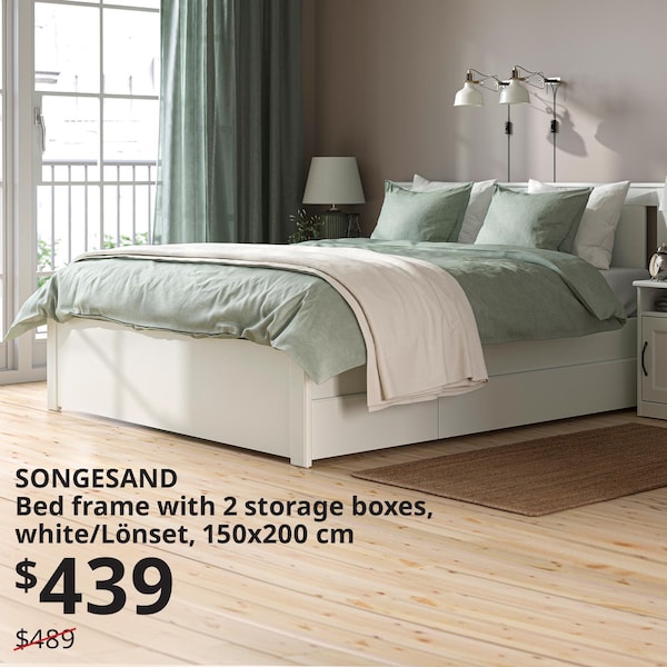 一个白色SONGESAND床在卧室里。有一个绿色的羽绒被和枕头套绿色和白色在床上。光照进卧室的窗户在床的右边。文字写着:SONGESAND床框架2存储箱,白色/ Lonset 150 x200cm, 439美元,先前的价格489美元。