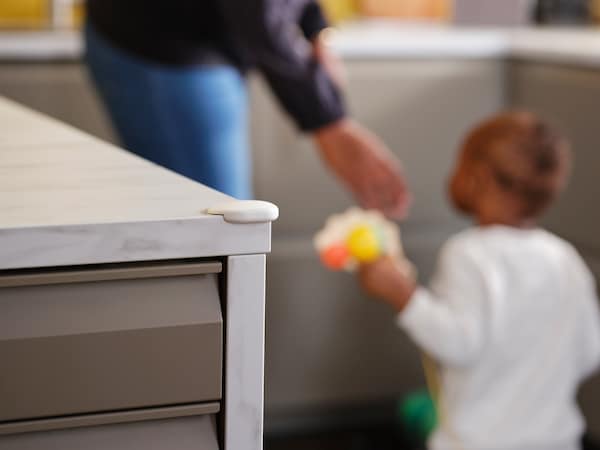 一个女人和一个孩子在一个厨房白色UNDVIKA角落保险杠的一角白色大理石桌面效果。