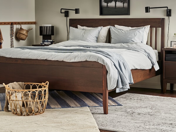 一个IDANAS床站在卧室的地板上米色TVERSTED地毯,浅灰色VEDBAK地毯和VRENSTED地毯。