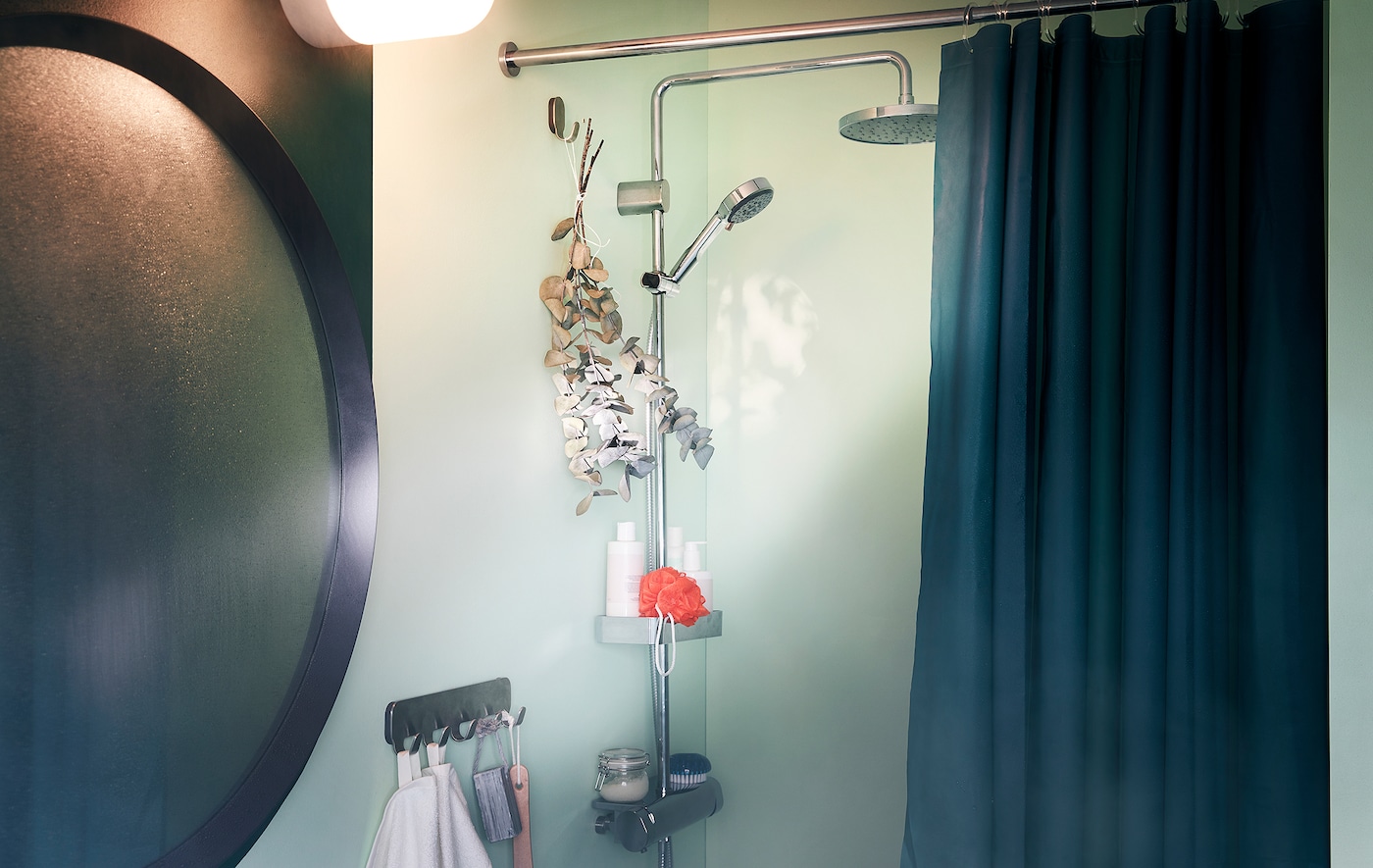 浴室的镜子蒙上了一层雾旁边淋浴配件和一束桉树枝挂在一个钩子。