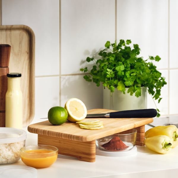柑橘类水果和一把刀在竹STOLTHET案板厨房柜台上新鲜草药和其他成分。