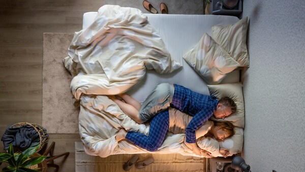 夫妻睡在床垫和床KLYNNETAG被套和枕套。