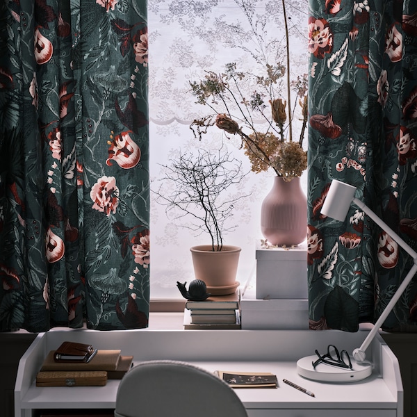 窗帘用花朵图案FILODENDRON织物在窗口上面白色米色转椅HAUGA书桌。