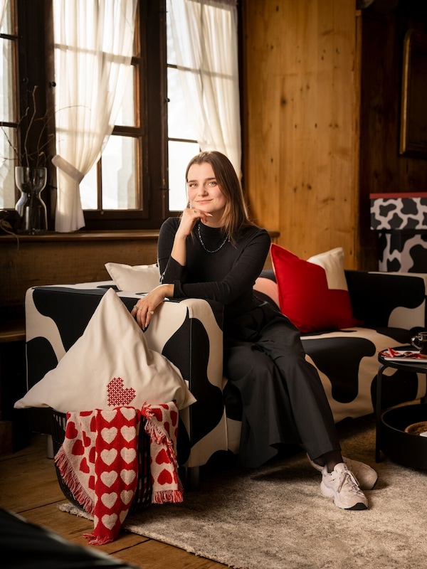 死Designerin露丝•德•马丁sitzt ganz在施瓦兹gekleidet auf einem KLIPPAN沙发和stutzt古老科夫麻省理工学院der rechten手。