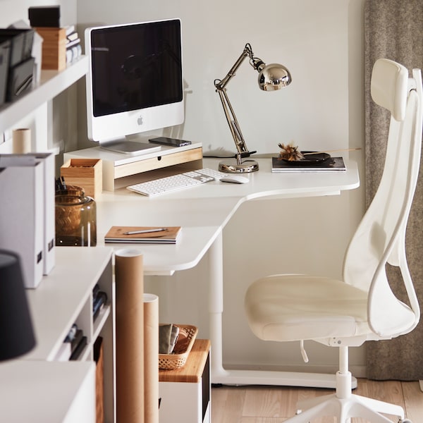 En kærm på En kærmhylde på et hvidt BEKANT jørneskrivebord med En JÄRVFJÄLLET kontorstol加上En hvid LACK væghylde。