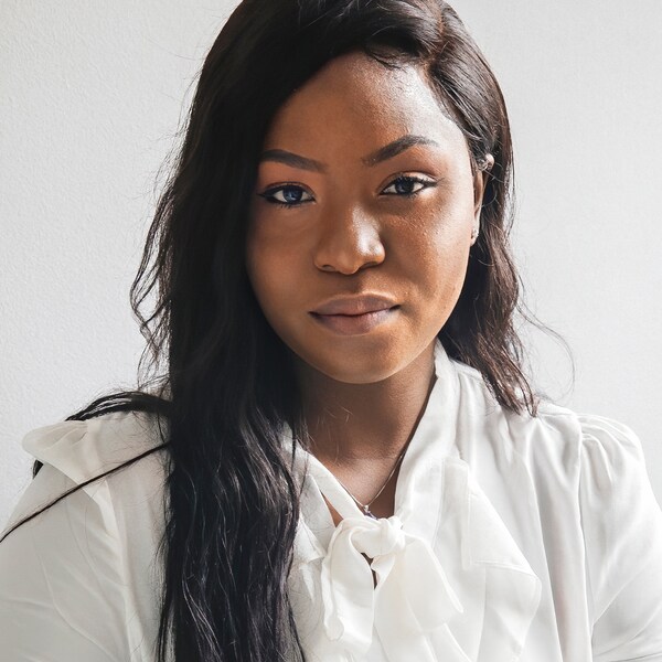 Et portræt af珍贵,en nigeriansk flygtning og medarbejder我宜家加拿大,ifør亚博平台信誉怎么样t en hvid skjorte pa en hvid baggrund。