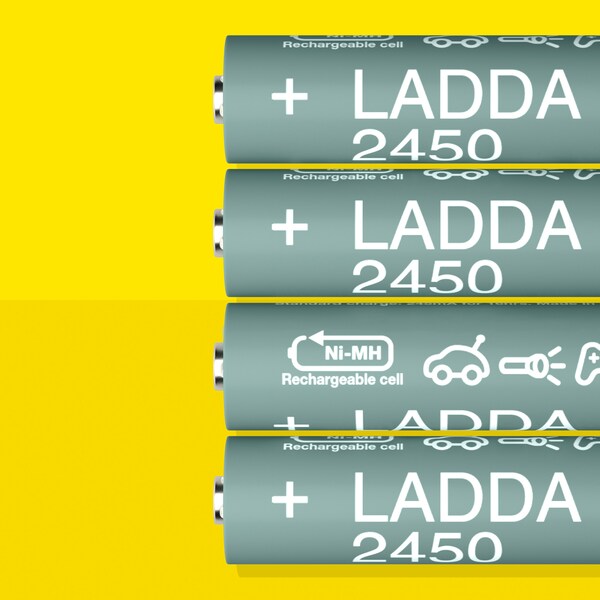 四个LADDA充电电池,HR6 AA电池容量为2450 mAh,躺在一排在一个黄色的表面。
