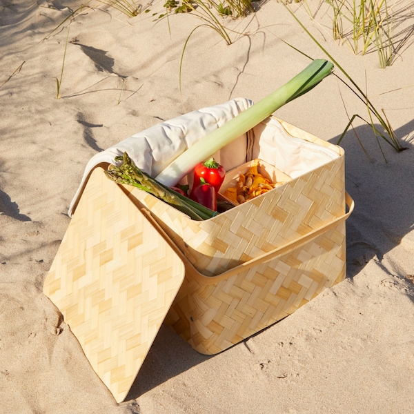 KASEBERGA酷篮子编织竹和棉花里持有不同的蔬菜,放在沙滩上。