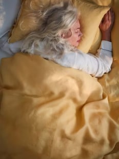 Kvinde iført en睡衣斯诺弗pa在居尔pude en gul格子。