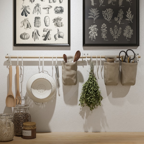 两个KNOPPÄNG框架，海报和NEREBY桦木栏杆在白墙上，挂着厨房用具和容器。
